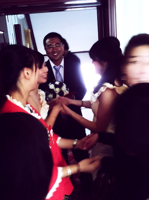 Traditional Chinese wedding customs: bridesmaids block groom from entering the bridal suite